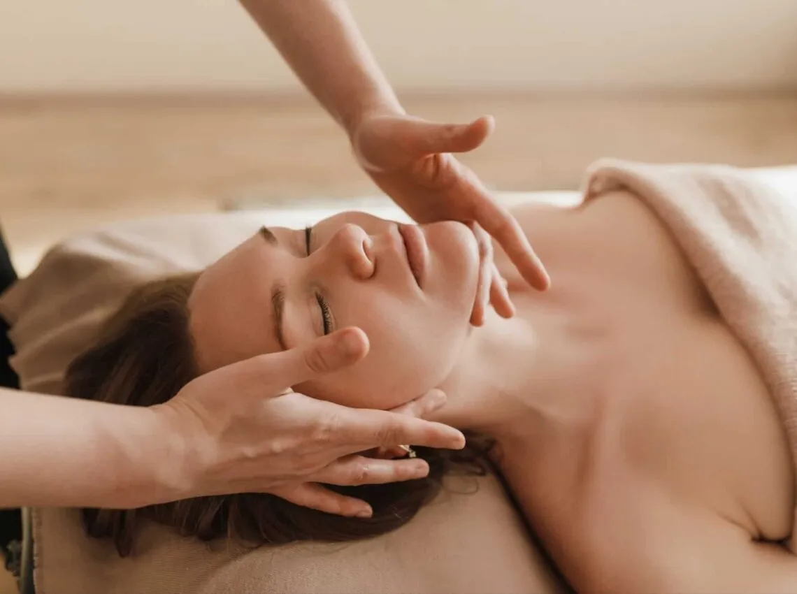 A woman receiving a relaxing facial massage.